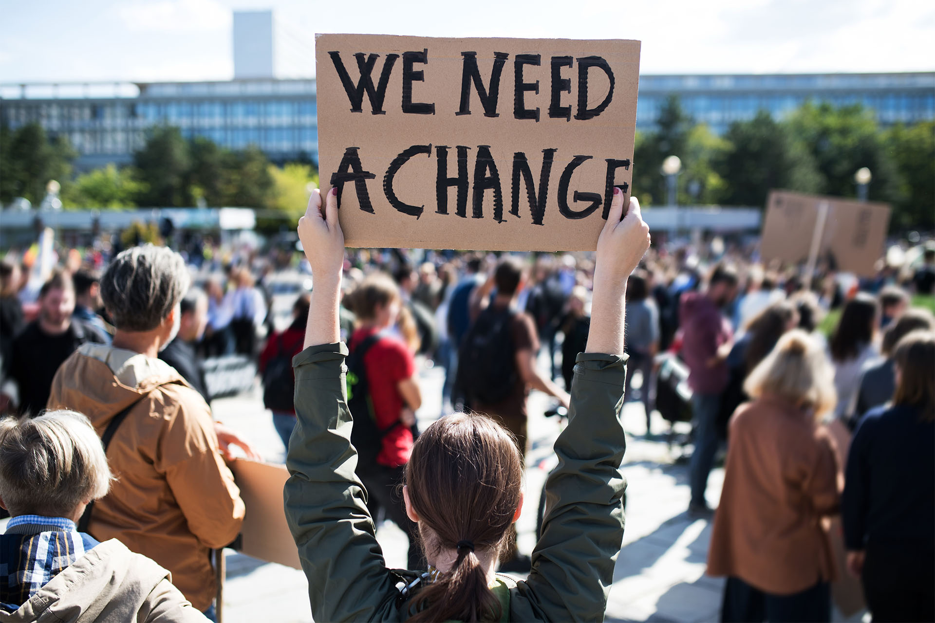 photo of advocates holding up a sign that says "we need a change" meant to signify the need for Hoosiers to show up at the Indiana Statehouse to advocate for clean air, water and energy