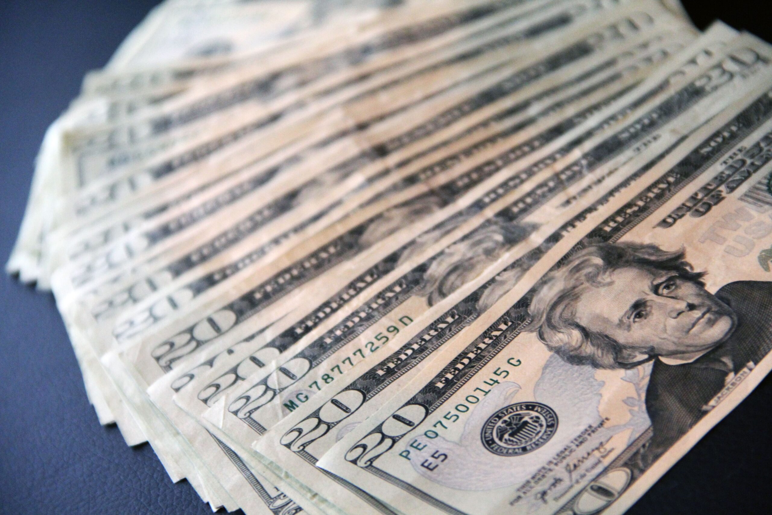photo of twenty dollar bills laid out on a table symbolizing utility rate hikes in the state of Indiana where Hoosiers are struggling to make ends meet amid rising rates